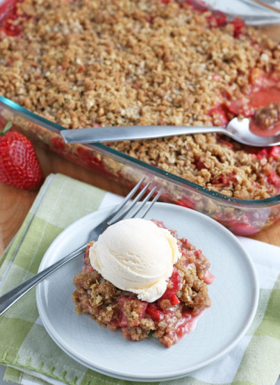 Strawberry Rhubarb crisp recipe finished in the pan and out of the oven and plated with a scoop of vanilla ice cream on top