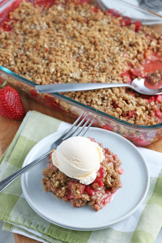 Strawberry & Rhubarb crisp recipe finished in the pan and out of the oven and plated with a scoop of vanilla ice cream on top