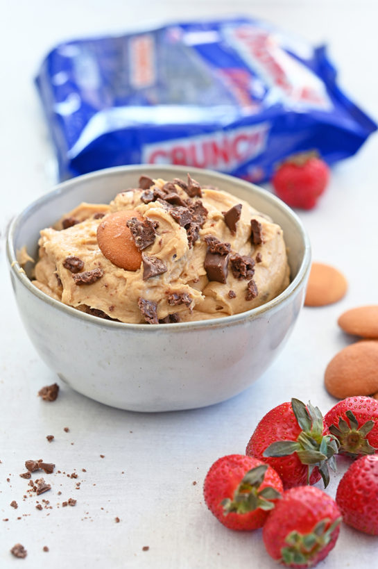 Indulgent Peanut Butter Crunch Bar Dip is a sweet dunkable dessert dip recipe that's perfect for parties and made in less than 10 minutes. Slice up an apple and dig in!