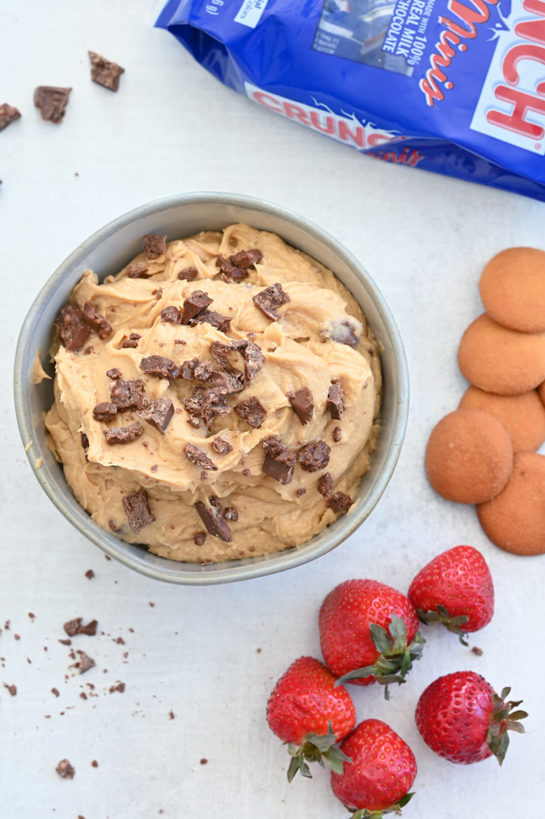 Indulgent Peanut Butter Crunch® Bar Dip is a sweet dunkable dessert dip recipe that's perfect for parties or game day and made in just 10 minutes. Slice up an apple and dig in!