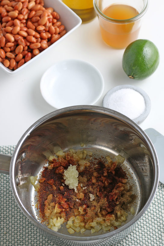 Adding the spices for the homemade refried beans