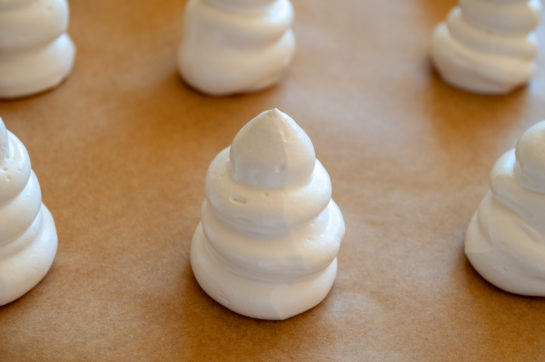 Piping the meringue to make the Halloween Boo Meringues Recipe