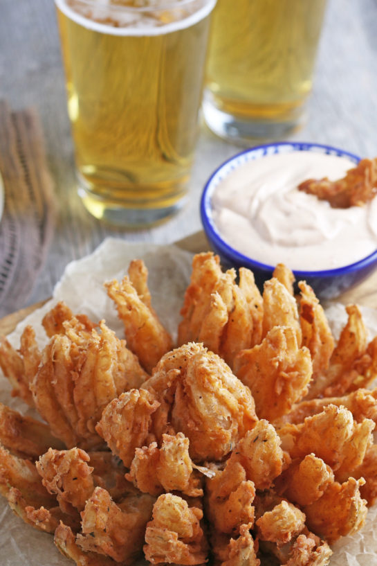 Deep-Fried Blooming Onion with a homemade dipping sauce is the ultimate appetizer recipe. Grab a sweet onion and turn it into a, incredible delicious snack!