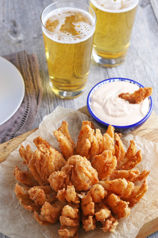 Fried Blooming Onion with a homemade dipping sauce is the ultimate appetizer recipe. Grab a sweet onion and turn it into a, incredible delicious snack!