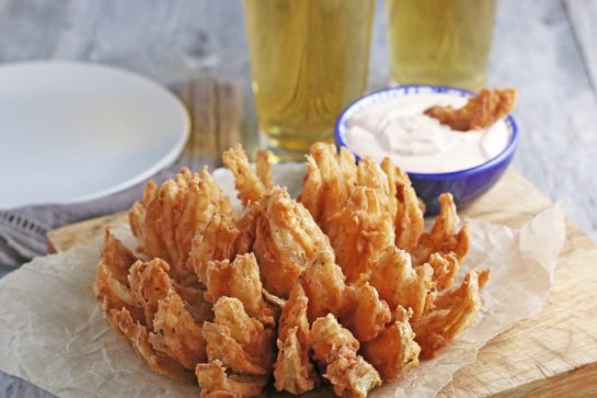 Fried Blooming Onion with a homemade dipping sauce is the ultimate appetizer recipe. Grab a sweet onion and turn it into a, incredibly delicious appetizer!