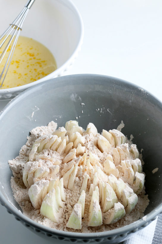 Dipping the onion in the batter for the blooming onion recipe