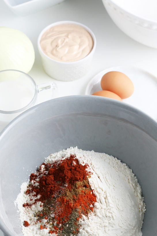 Adding the dry ingredients needed to make fried blooming onion recipe