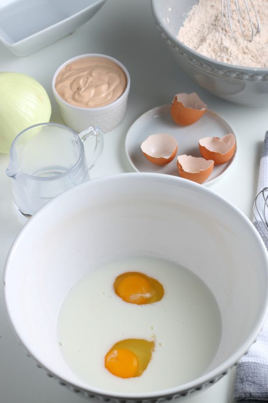 Adding the eggs to the the dry ingredients to make fried blooming onion recipe