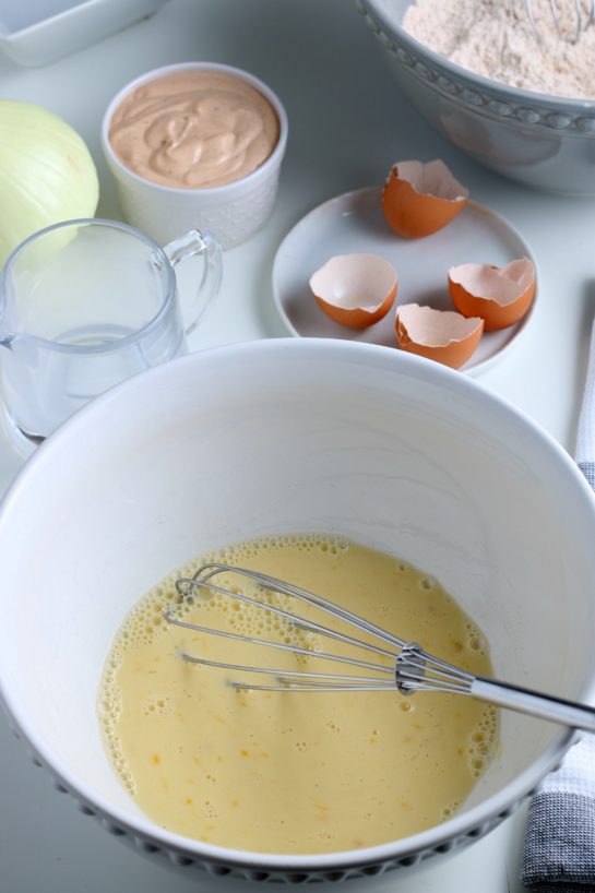 Mixing the eggs to make fried blooming onion recipe