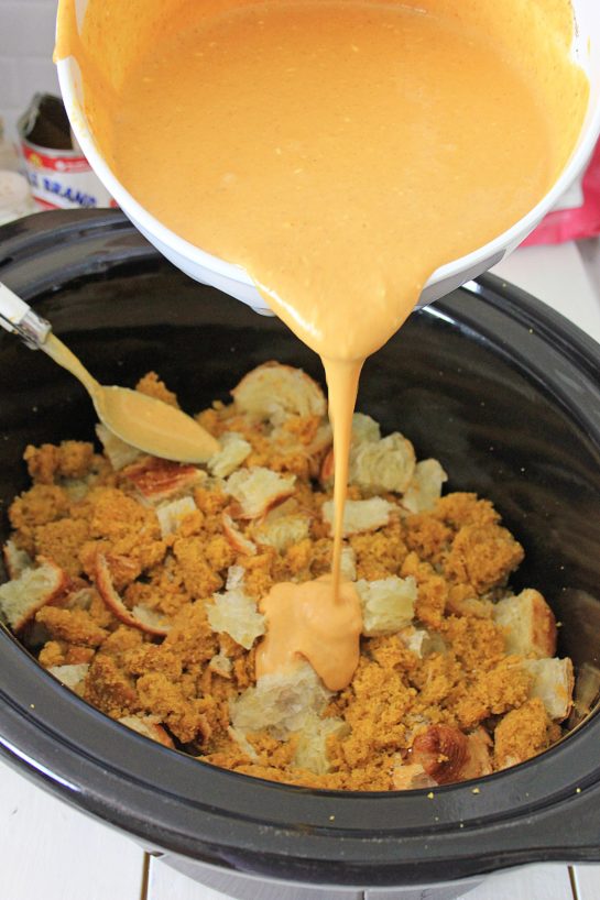 Adding the wet ingredients to the crock pot for the crock pot pumpkin bread pudding