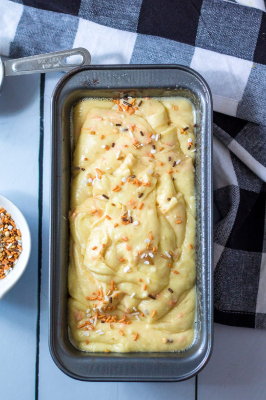 Adding the batter to the bread loaf pan for the Fall Confetti Sweet Bread recipe 