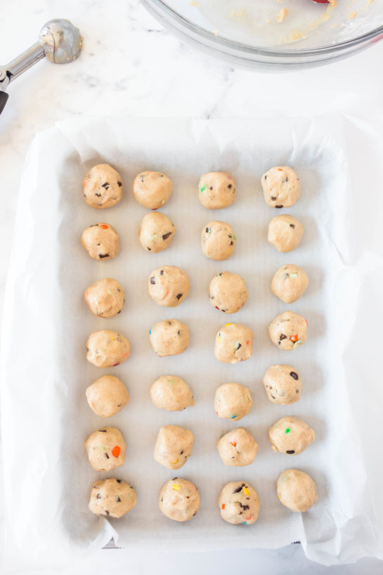 Scooping out the dough and adding to the baking tray for Edible Cookie Dough Bombs recipe