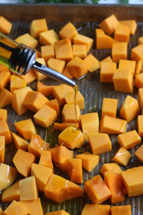 Placing the diced butternut squash on the pan for the roasted butternut squash recipe