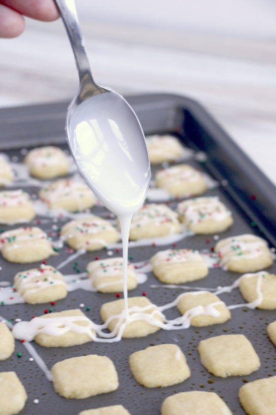 Drizzling the icing for the Christmas Sugar Cookie Bites recipe