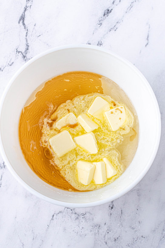 Adding the butter needed to make the Microwave Peanut Brittle recipe