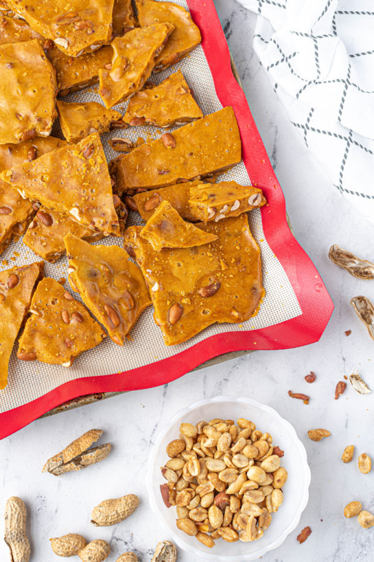 Breaking apart the brittle on the baking pan to make the Microwave Peanut Brittle recipe