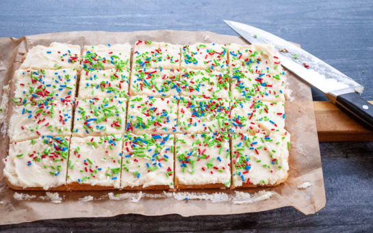 This Holiday Sugar Cookie Bars recipe is the easiest way to make sugar cookies! They are SO delicious topped off with a sweet, creamy icing!