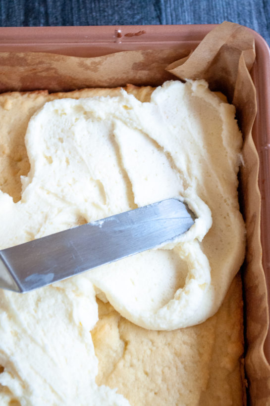 Spreading the frosting on the sugar cookie bars recipe