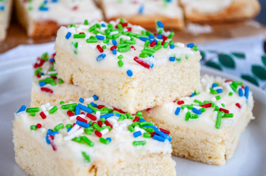 Close up of the stacked Holiday Sugar Cookie Bars cut up and on a plate for serving for Christmas or any holiday