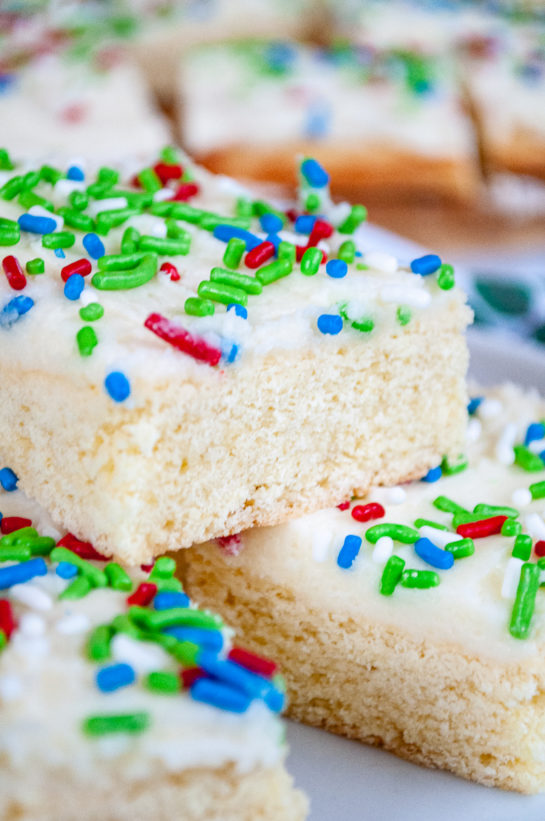 Close-up image of the Holiday Sugar Cookie Bars cut up and on a plate for serving