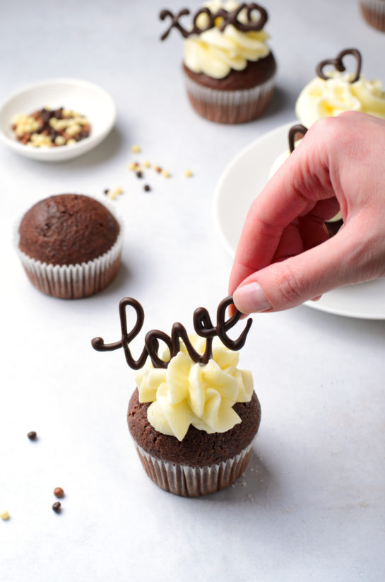 Placing the chocolate words on top for the Valentine's Day Lover's Chocolate Cupcakes 