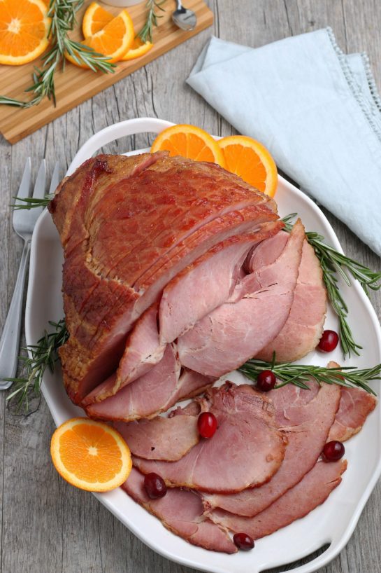 Overhead shot of the plated Glazed Spiral Ham recipe with a sweet glaze uses a fully-cooked ham and is a great centerpiece for your Christmas, Easter, or Thanksgiving dinner table! The flavor and texture will be a show-stopper!
