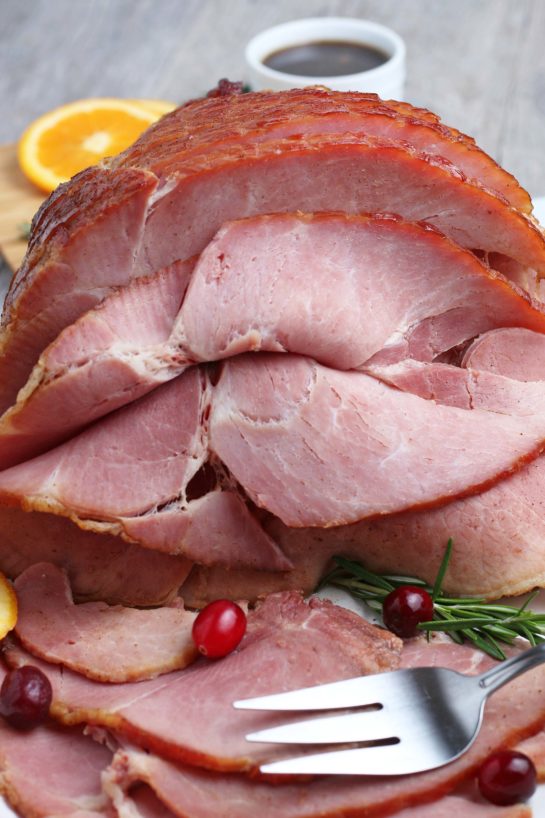 Close-up shot of recipe for Glazed Spiral Ham with a sweet glaze uses a fully-cooked ham and is a great centerpiece for your Christmas, Easter, or Thanksgiving dinner table! The flavor and texture will be a show-stopper!
