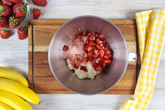 Strawberries being mixed in for the no-bake banana split cheesecake recipe