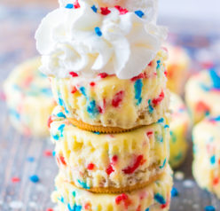 Mini Red, White, and Blue Cheesecakes recipe layered with a Golden Oreo crust and creamy tangy cheesecake. Top with sprinkles and whipped cream for the perfect patriotic dessert for 4th of July!
