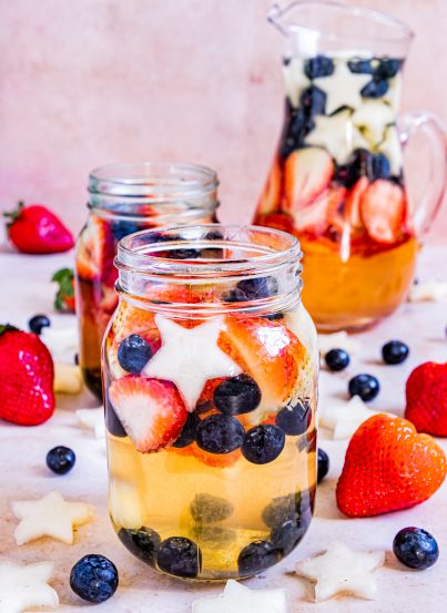 Sip on my Patriotic Sangria recipe this summer to enjoy a cocktail while beating the heat at the same time! With fresh blueberries, strawberries, white grape juice, brandy, and wine, it's perfect for Flag Day, 4th of July or Memorial Day!