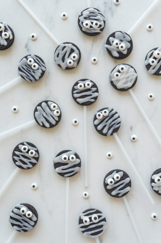 Cute Halloween Mummy Oreo Pops are an adorable recipe and so easy to make! With just a few ingredients and a fun time decorating, you will have these super cute treats that kids will love!