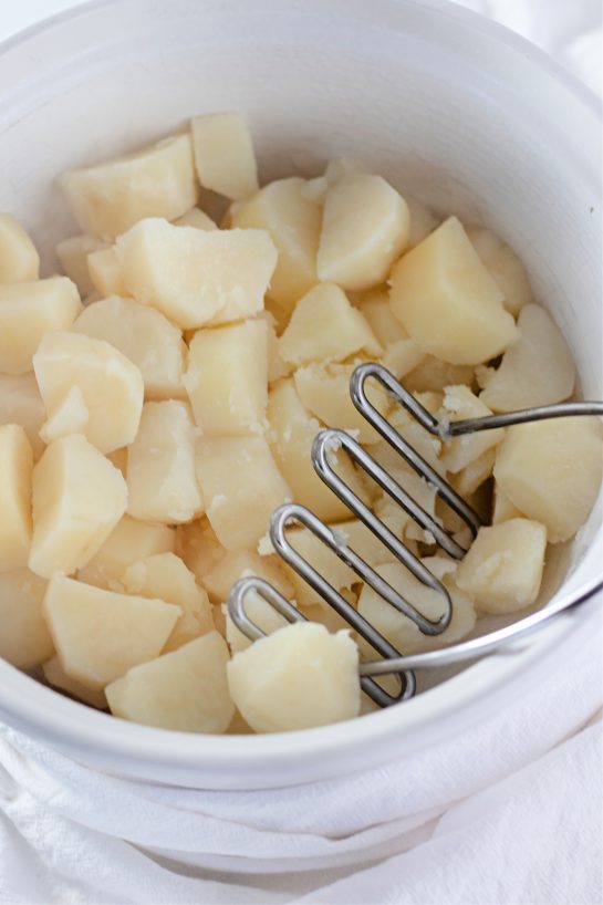 Mashing the potatoes for Amish mashed potatoes recipe