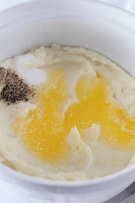 Pouring the browned butter over the potatoes for the Amish mashed potatoes recipe