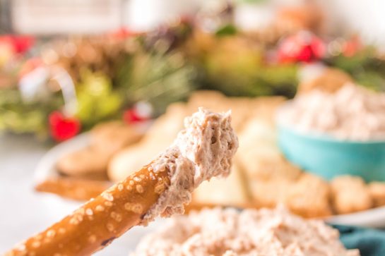 Dipping pretzels in the Cinnamon Roll Dip recipe for Christmas or holiday dessert