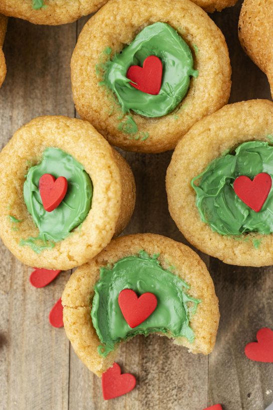 Dr. Suess' the Grinch Cookie Cup Bites recipe is inspired by Dr. Seuss’s How the Grinch Stole Christmas! They are chewy sugar cookies that have been colored green and adorned with a red heart for a fun holiday dessert! 