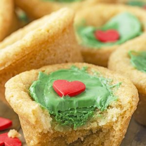 Grinch Cookie Cup Bites recipe is inspired by Dr. Seuss’s How the Grinch Stole Christmas book/movie! They are chewy sugar cookies that have been colored green and adorned with a red heart for a fun holiday dessert! 