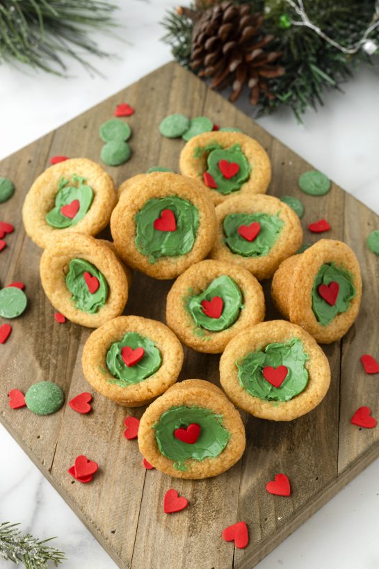 Easy Grinch Cookie Cup Bites recipe is inspired by Dr. Seuss’s How the Grinch Stole Christmas! They are chewy sugar cookies that have been colored green and adorned with a red heart for a fun holiday dessert! 