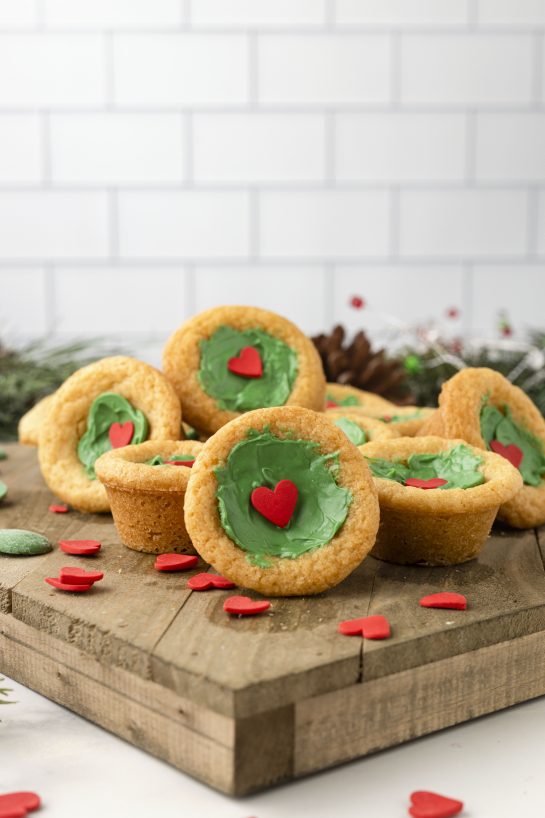Green Grinch Cookie Cup Bites recipe is inspired by Dr. Seuss’s How the Grinch Stole Christmas! They are chewy sugar cookies that have been colored green and adorned with a red heart for a fun holiday dessert! 