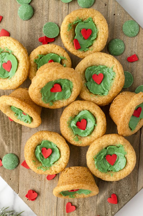 Grinch Cookie Cup Bites recipe is inspired by Dr. Seuss’s How the Grinch Stole Christmas! They are chewy sugar cookies that have been colored green and adorned with a festive red heart for a fun holiday dessert! 