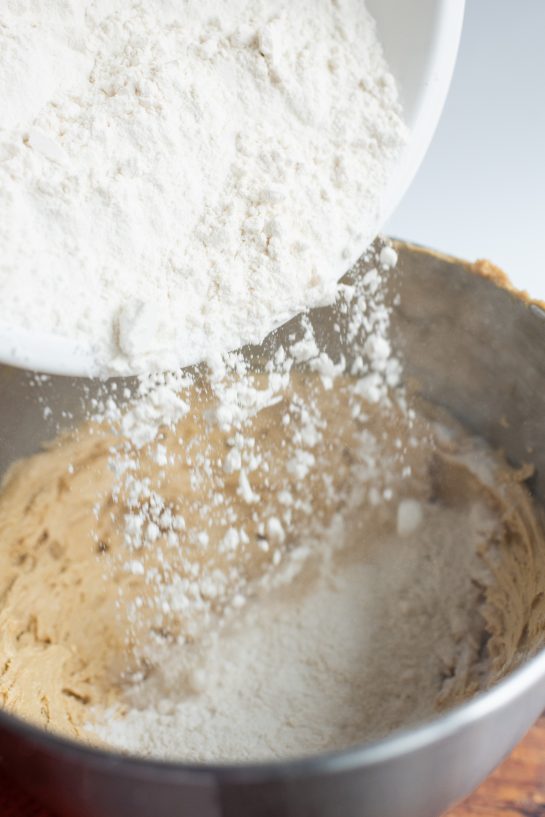 Pouring in the flour needed for the Peanut Butter Thumbprint Cookies recipe 