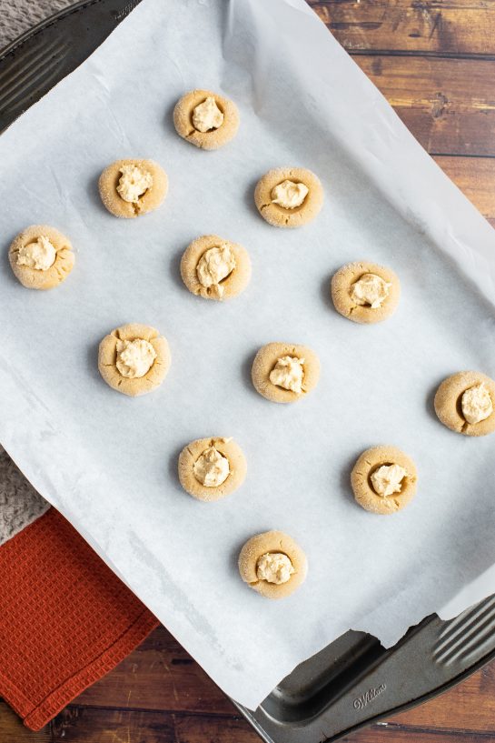 Scooping the filling in for the Peanut Butter Thumbprint Cookies recipe 