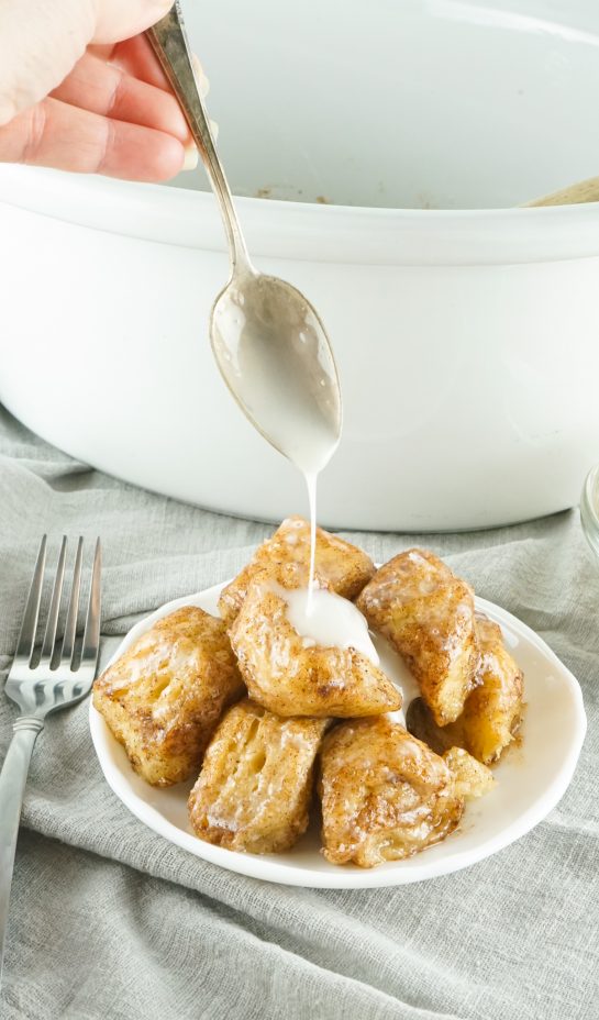 Slow Cooker Monkey Bread turns your classic monkey bread recipe into a delicious slow cooker creation. Full of delicious biscuits, coated in cinnamon and sugar, then drizzled with a rich icing. Perfect for brunch, breakfast or dessert.