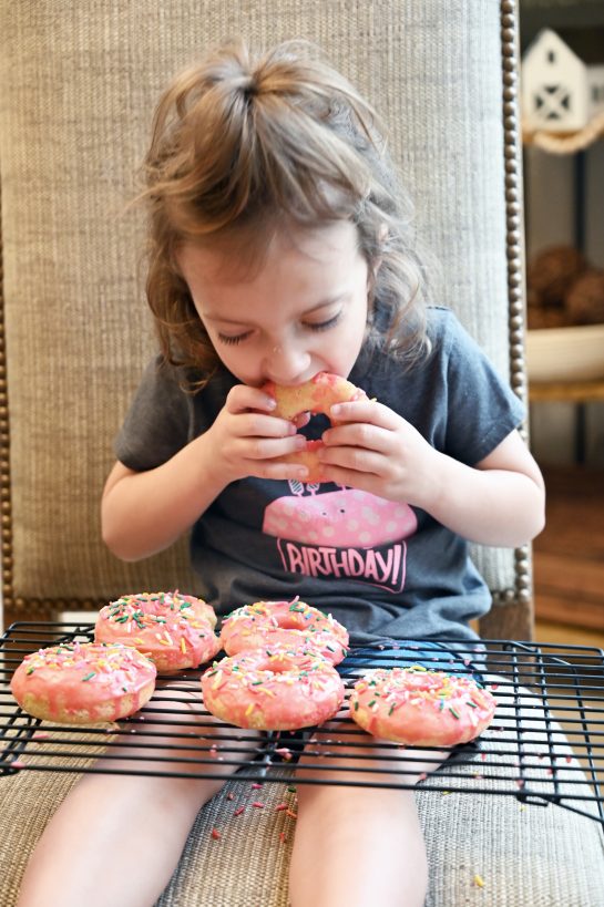 Photo of my daughter eating the finished Vanilla-Glazed Baked Donuts recipe