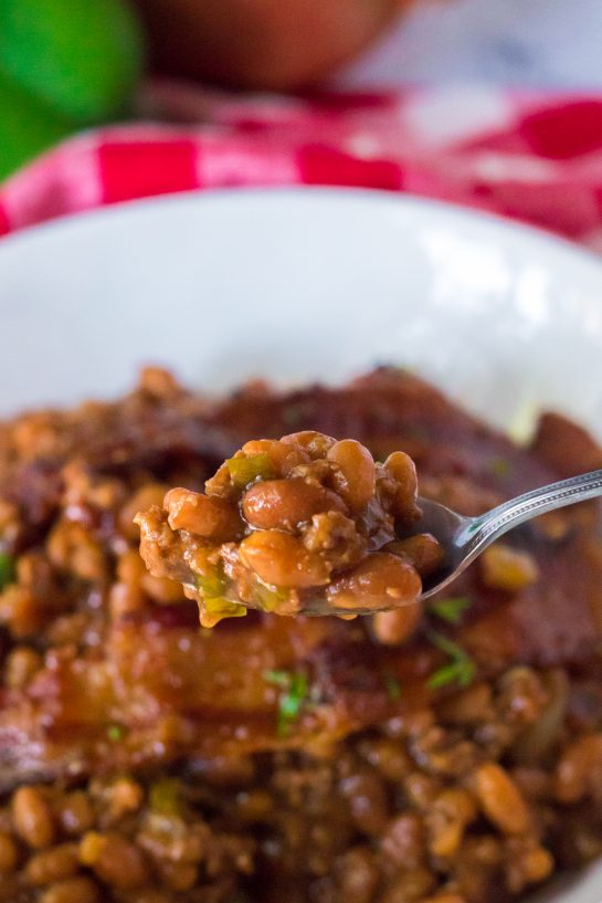 Easy Beefy Baked Beans are my favorite side dish recipe for summer cook-outs! Beans get mixed with ground beef, onion and bell pepper, brown sugar, ketchup, mustard and Worcestershire before getting topped with a peppered brown sugar bacon.
