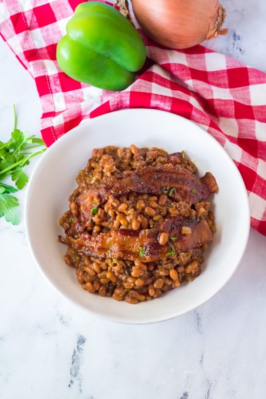 Beefy Baked Beans are my favorite for a BBQ or picnic! Beans get mixed with ground beef, onion and bell pepper, brown sugar, ketchup, mustard and Worcestershire before getting topped with a crispy, peppered brown sugar bacon.