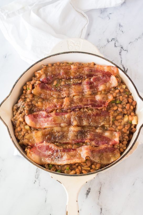 Placing the cooked bacon on top of the pot to make the beefy baked beans side dish recipe