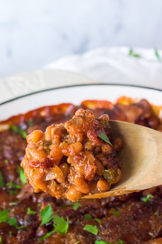 Beefy Baked Beans are my favorite side dish recipe! Beans get mixed with ground beef, onion and bell pepper, brown sugar, ketchup, mustard and Worcestershire before getting topped with a peppered brown sugar bacon.