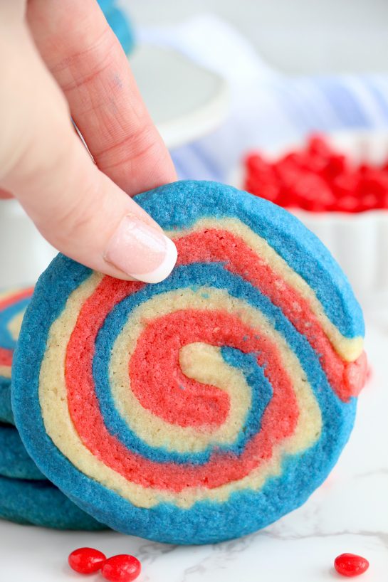 Easy Patriotic Pinwheel Cookies are a classic, slice and bake soft sugar cookie recipe all dressed up for the 4th of July! These patriotic pinwheel cookies have beautiful swirls of red, white and blue. 