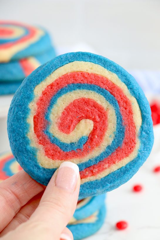 Patriotic Pinwheel Cookies are a classic, slice and bake soft sugar cookie recipe all dressed up for the 4th of July! These patriotic pinwheel cookies have beautiful swirls of red, white and blue. 