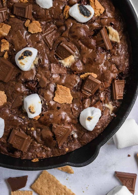 You don't need a campfire to enjoy this rich S'mores Brownie Skillet--a treat that will have you wanting s'more! Gooey marshmallows, graham crackers baked right into the brownie and chocolate bars are all part of this fudgy brownie that is best eaten with a spoon! Simple to toss together but won't last long!